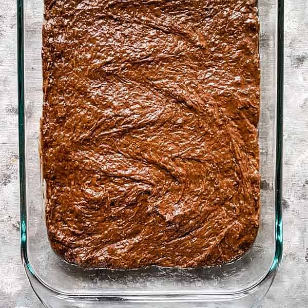 zucchini brownie batter in greased glass baking dish