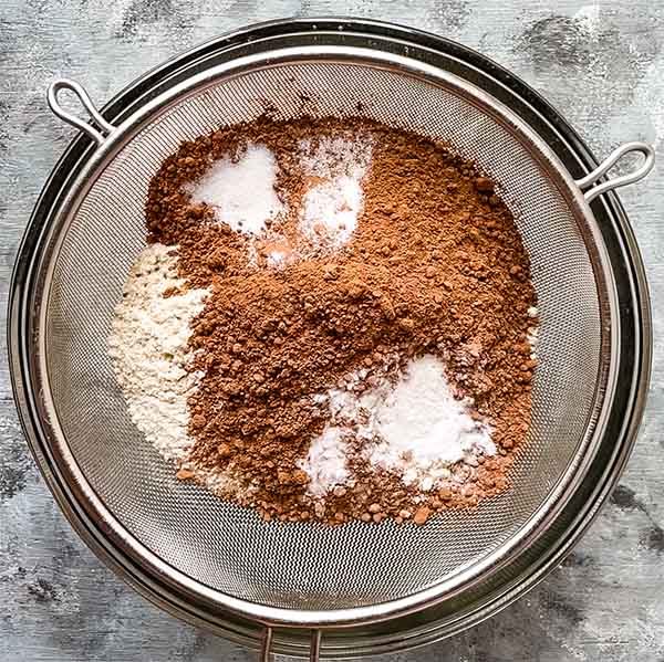 dry ingredients, flour, cocoa powder, baking soda, salt, in sifter over glass bowl