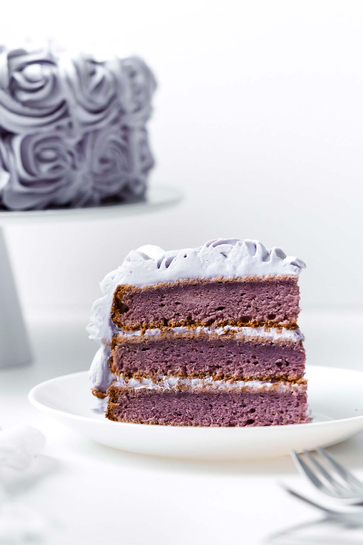 Purple yam cake slice on small white plate