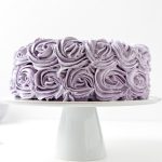 Ube Halaya Cake with purple frosting roses on white cake stand