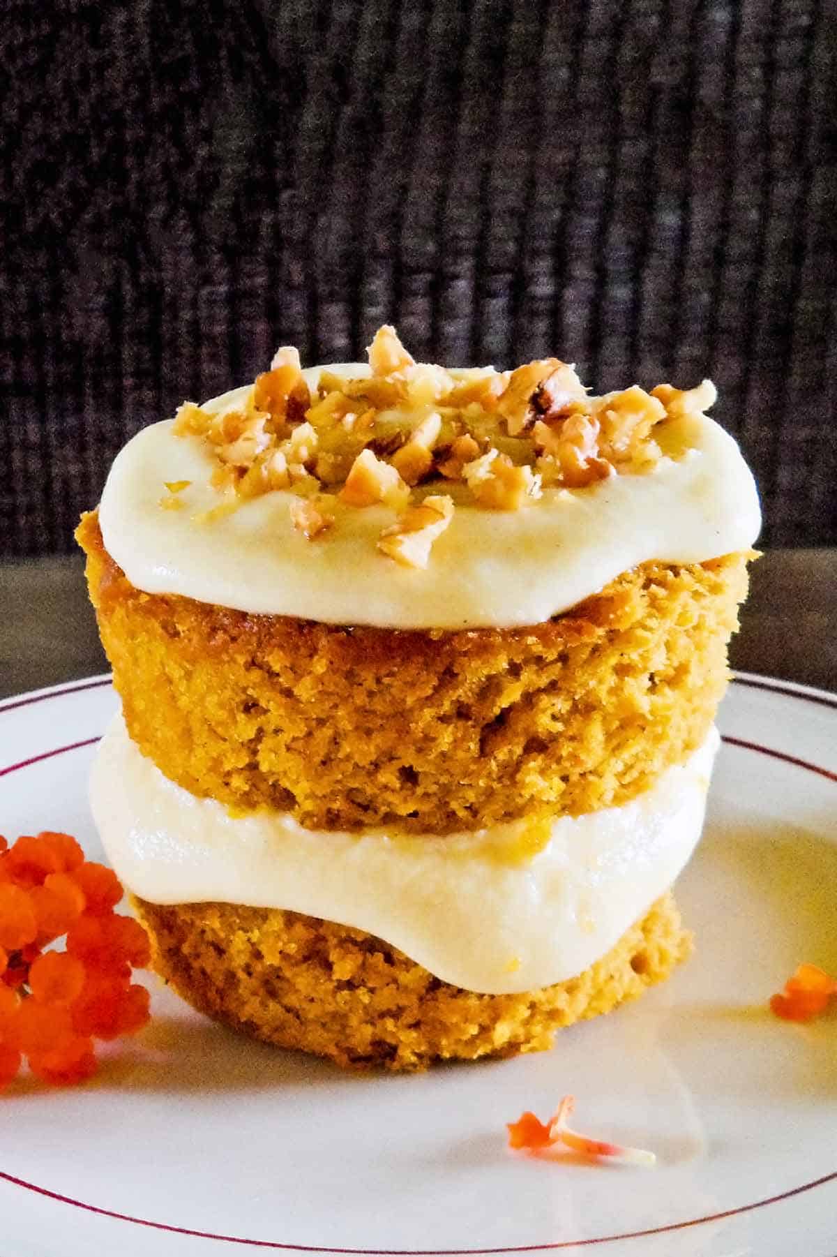 the best pumpkin cake with cream cheese frosting and walnuts on small white plate