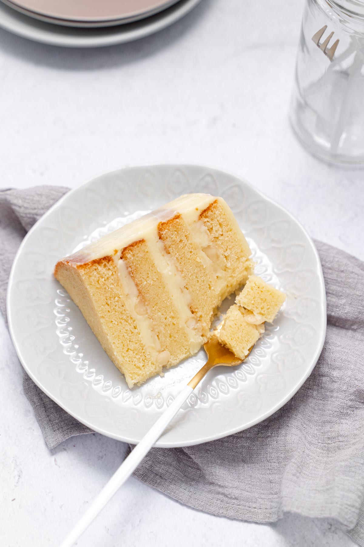 white chocolate macadamia nut cake slice with fork taking piece out