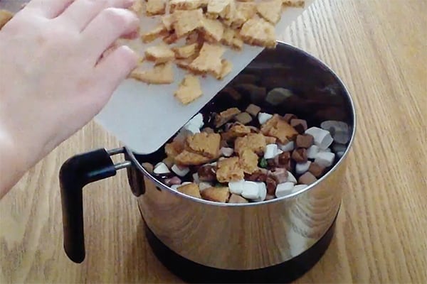 mixing melted chocolate with marshmallows, candy, biscuits