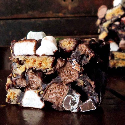 close up of rocky road square with visible marshmallow, cookie and chocolate candy bits