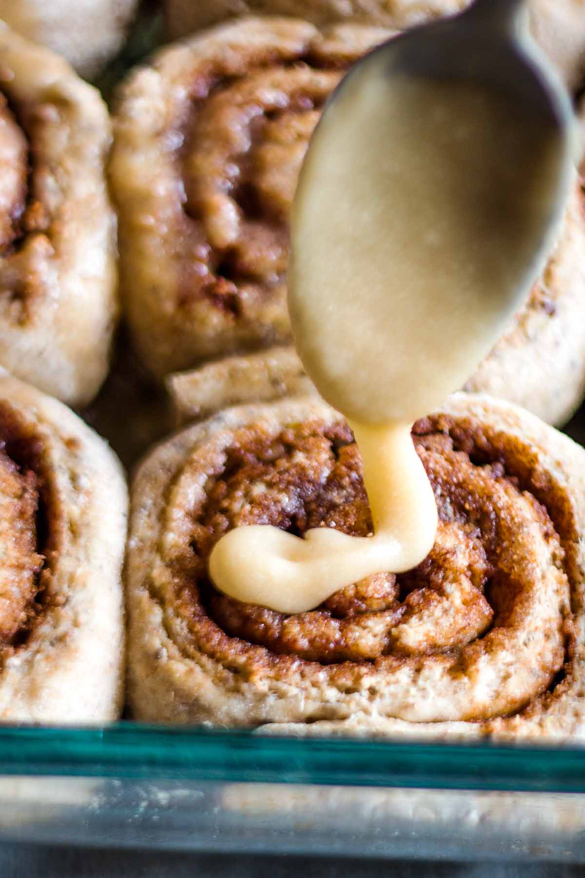 Healthy Cinnamon buns being glazed with icing