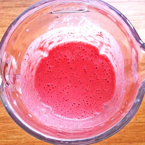 glass blender jug with blended strawberry mix