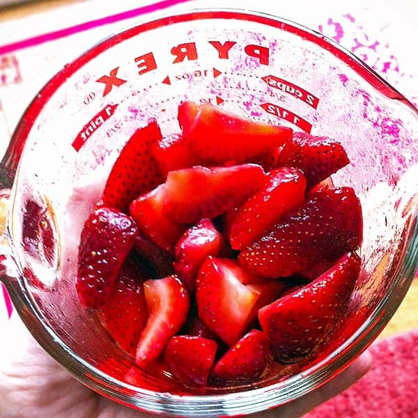measuring jar with cut up strawberries