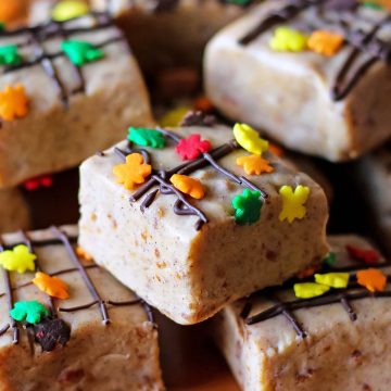 pumpkin pie fudge squares with chocolate drizzle and fall leaves sprinkles stacked on top of each other