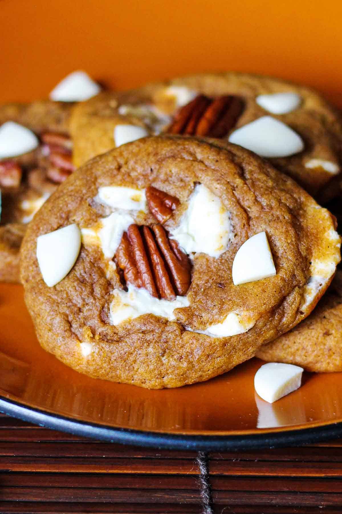 white chocolate chip and pumpkin cookies on an orange plate