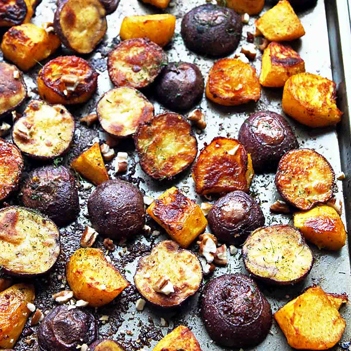 roasted baby potato halves and squash cubes on baking sheet