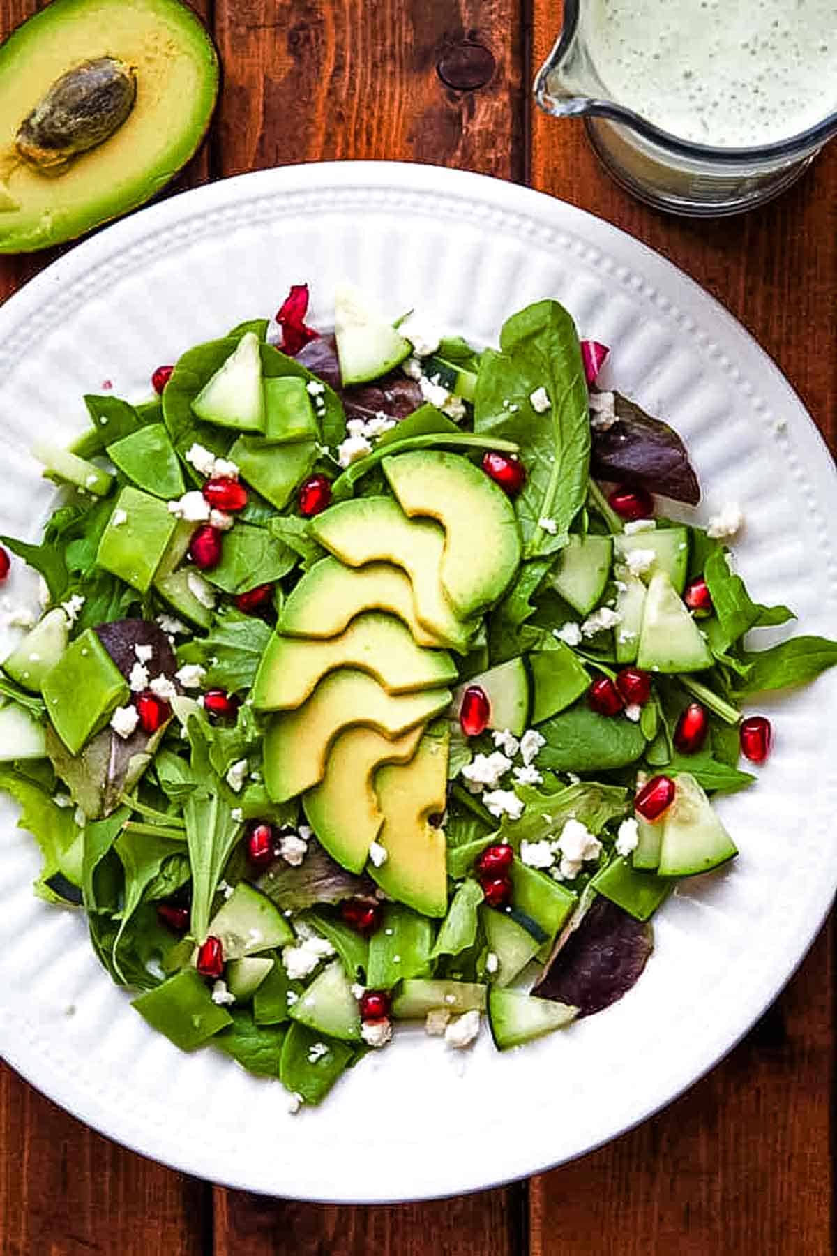 green salad with avocado and green goddess dressing on the side