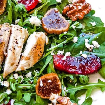 green salad with grilled chicken slices, dried figs, oranges, and walnuts