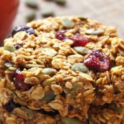 These healthy pumpkin breakfast cookies make a nutritious and portable breakfast that tastes like fall! This gluten-free + clean eating breakfast treat is made with wholegrain oats, cranberries, pumpkin seeds + honey