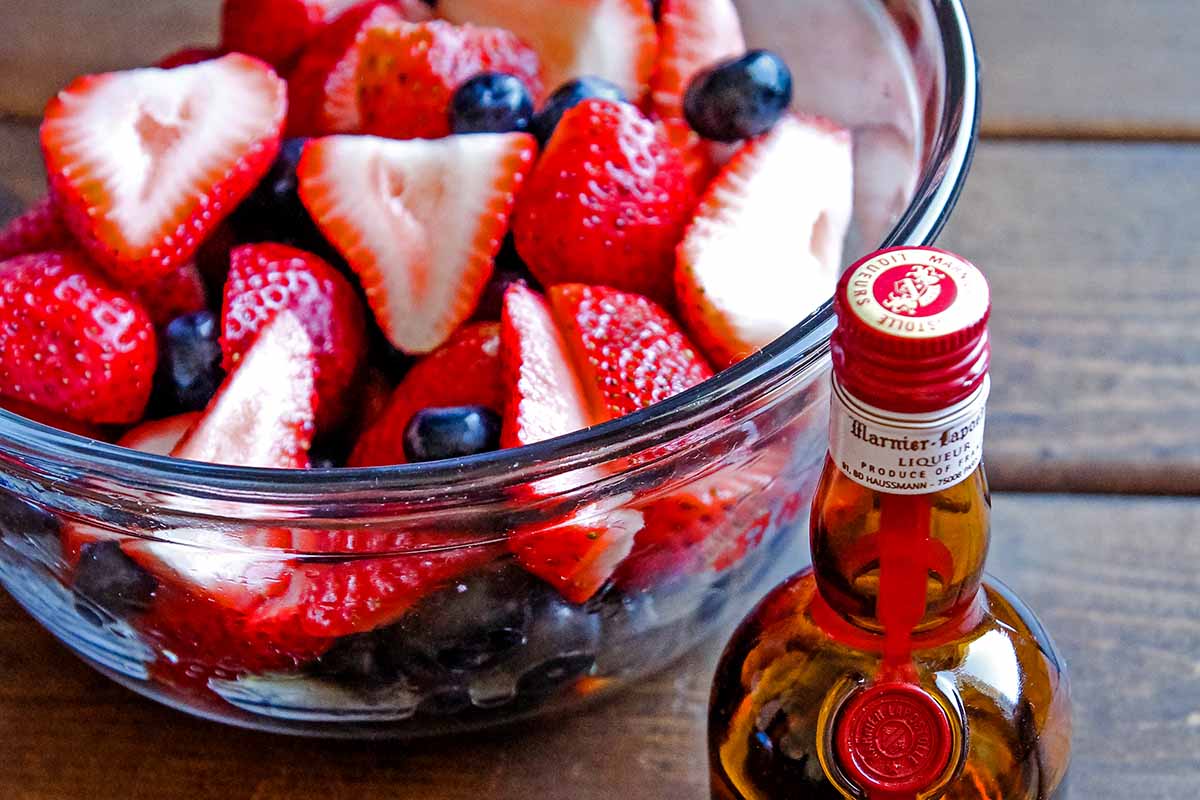 berries in a bowl and small bottle of Grand Marnier