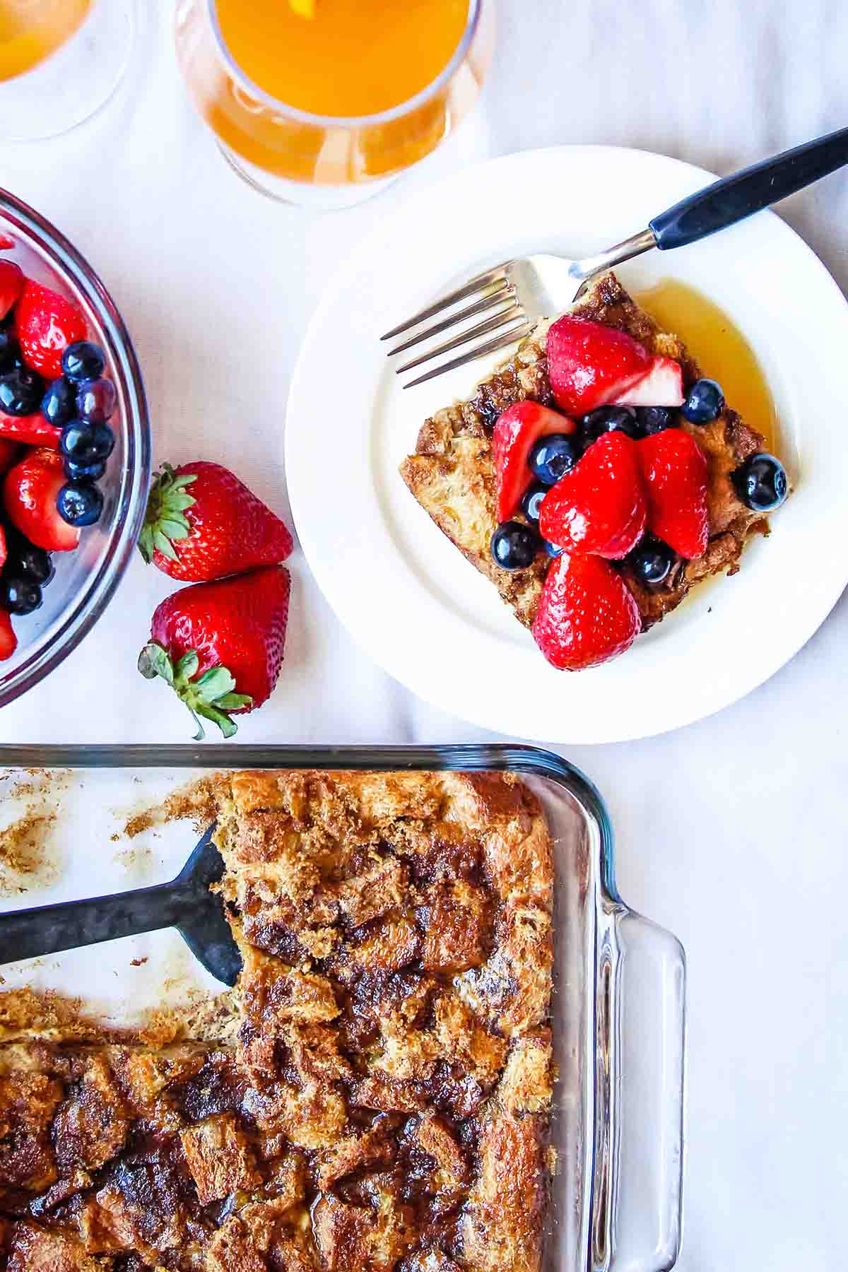 Oven french toast in glass dish and plated serving with berries