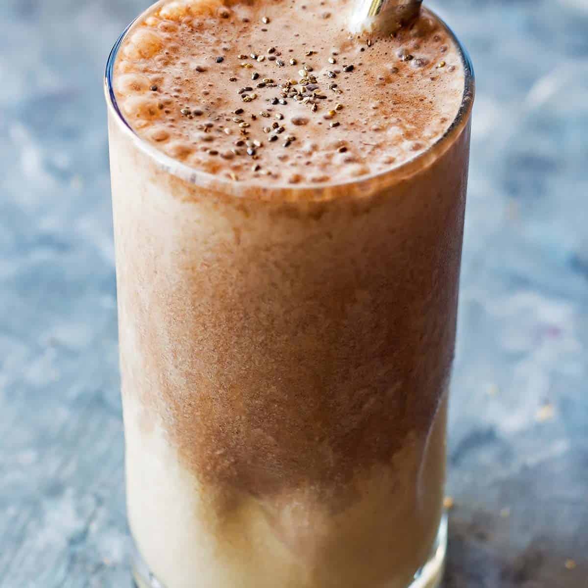 protein shake in glass with peanut butter layer on the bottom and chocolate layer on top