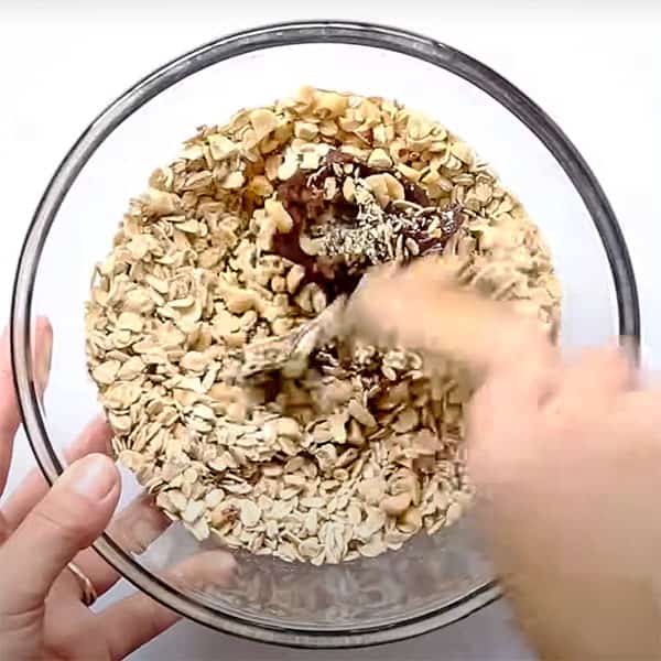 mixing oats and peanuts with chocolate mixture