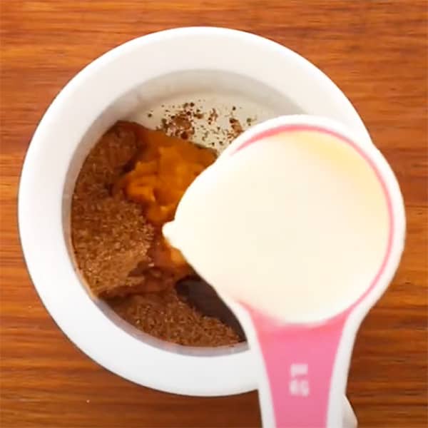 wet ingredients for baked pumpkin pie oatmeal added to white mug