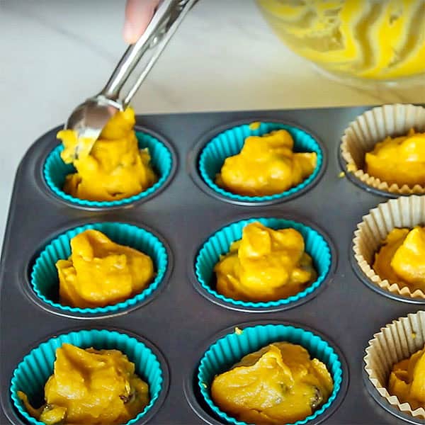 dividing coconut flour pumpkin muffins batter