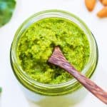 Kale pesto in a jar with small spoon inside