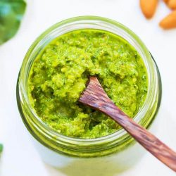Kale pesto in a jar with small spoon inside