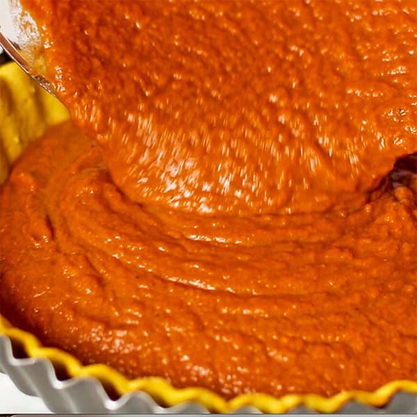 pouring pumpkin pie filling