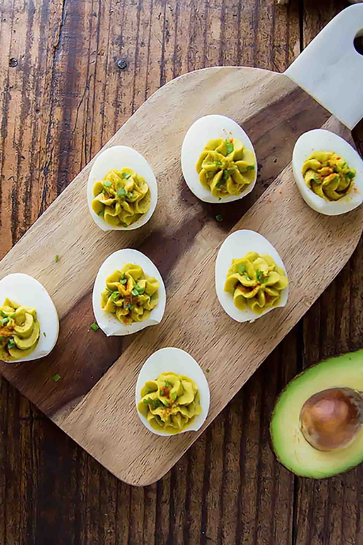 Avocado deviled eggs on cutting board