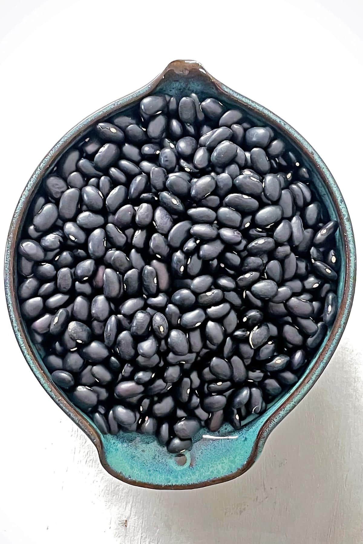 Dry black beans in small blue bowl