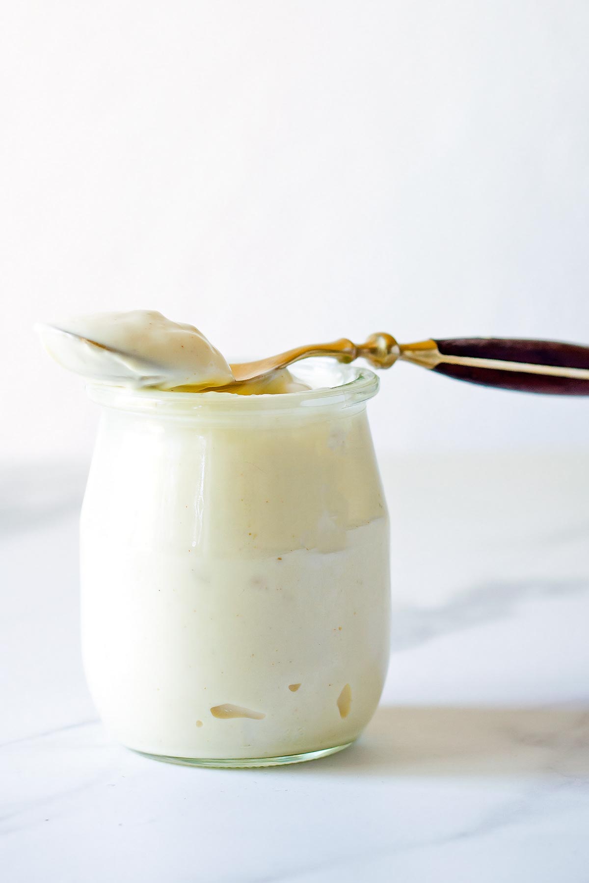 Spoonful of mayo on top of a small jar