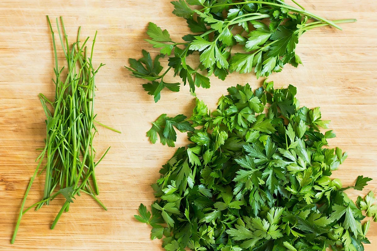 Parsley, leaves, and stems on cutting board