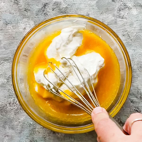 whisk mixing honey, butter, egg, Greek yogurt
