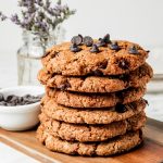 Stack of Almond Flour Cookies, chocolate chips in bowl, flower vase in background