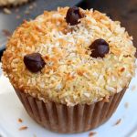 Almond butter muffin with shredded coconut topping on small white stand