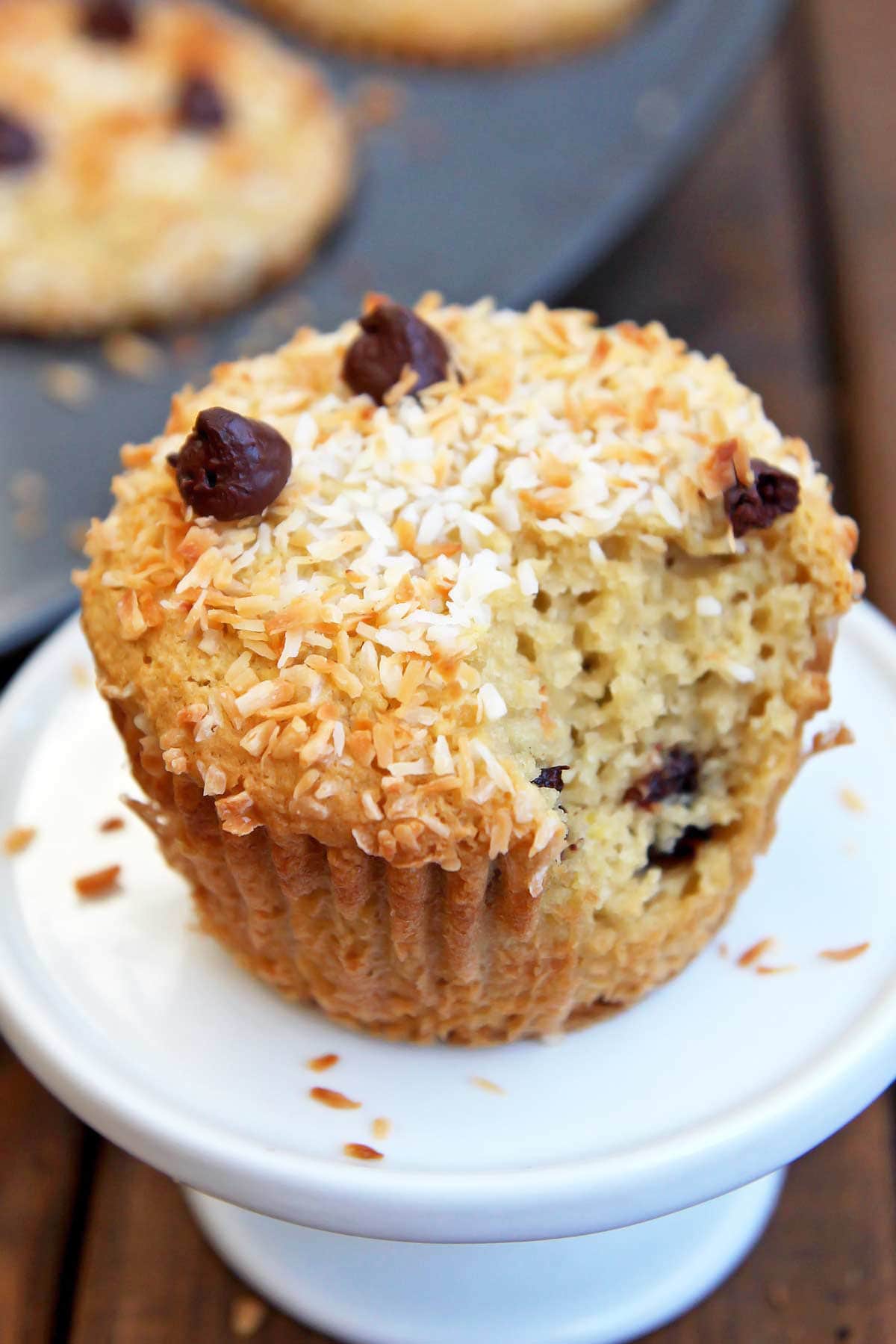 Coconut flour almond butter muffin with chocolate chips and bite taken out to reveal inside texture