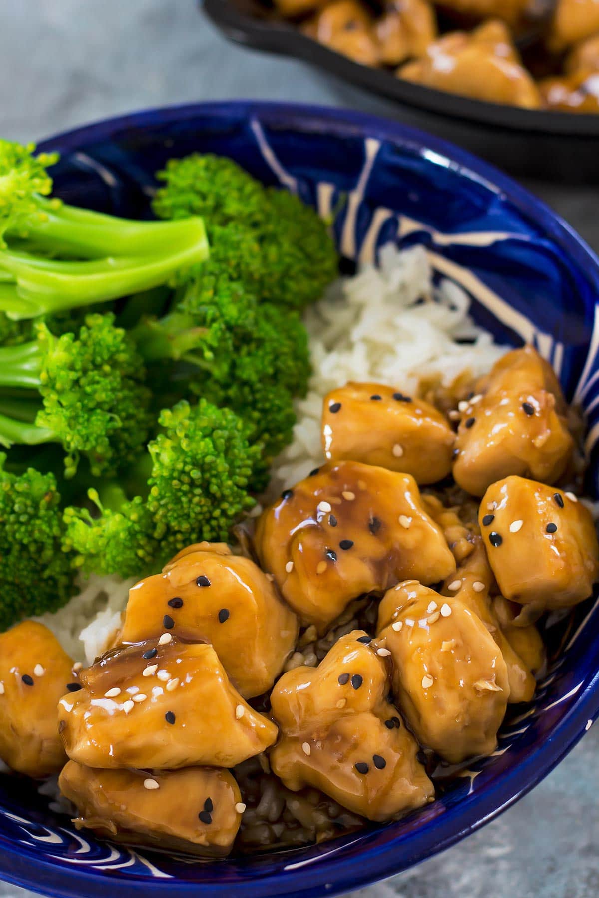 Teriyaki chicken in blue bowl of rice with broccoli