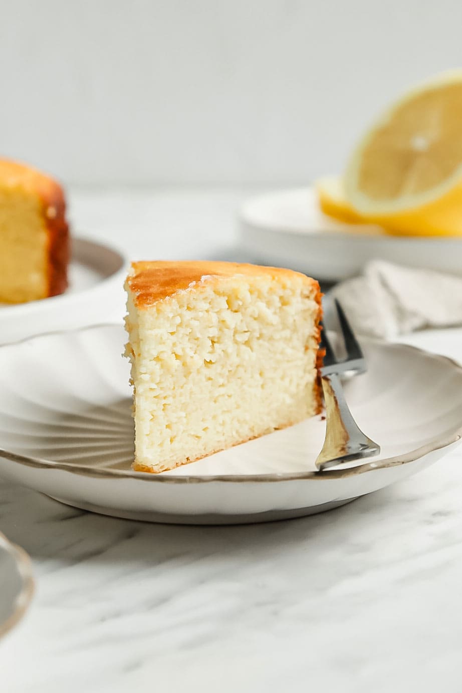 Close up lemon coconut flour cake slice on small white saucer