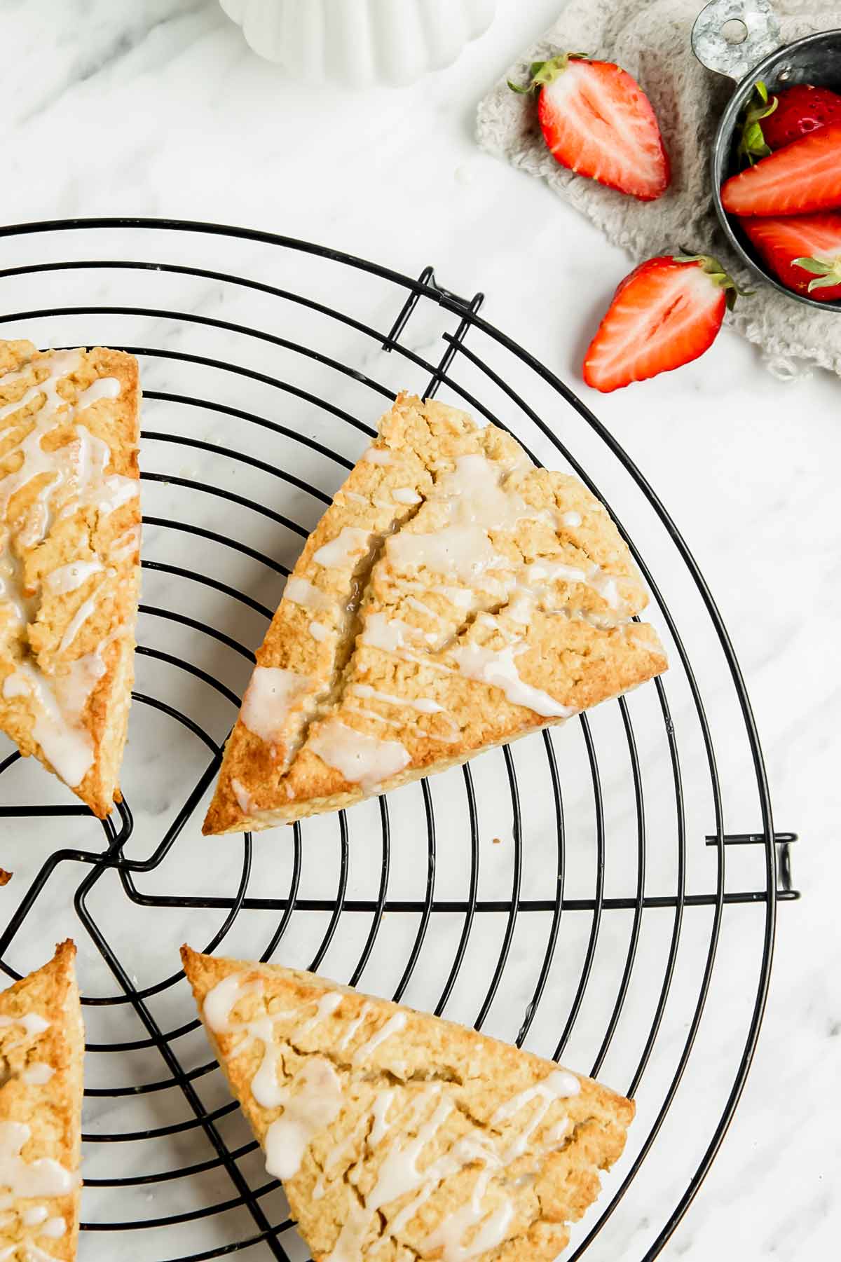 Coconut flour scones on circular wire rack, strawberries on the side