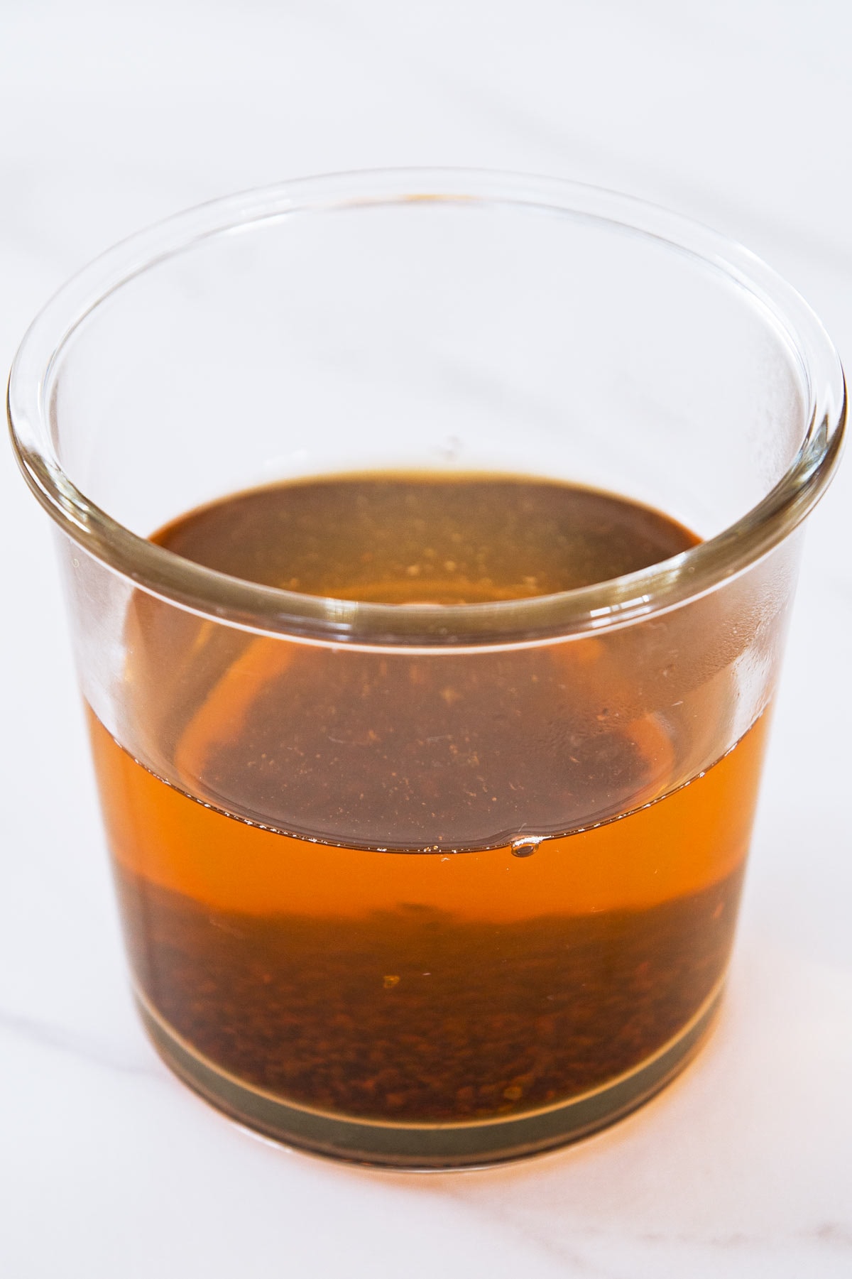 Strong sweet black tea with tea leaves at bottom in a glass