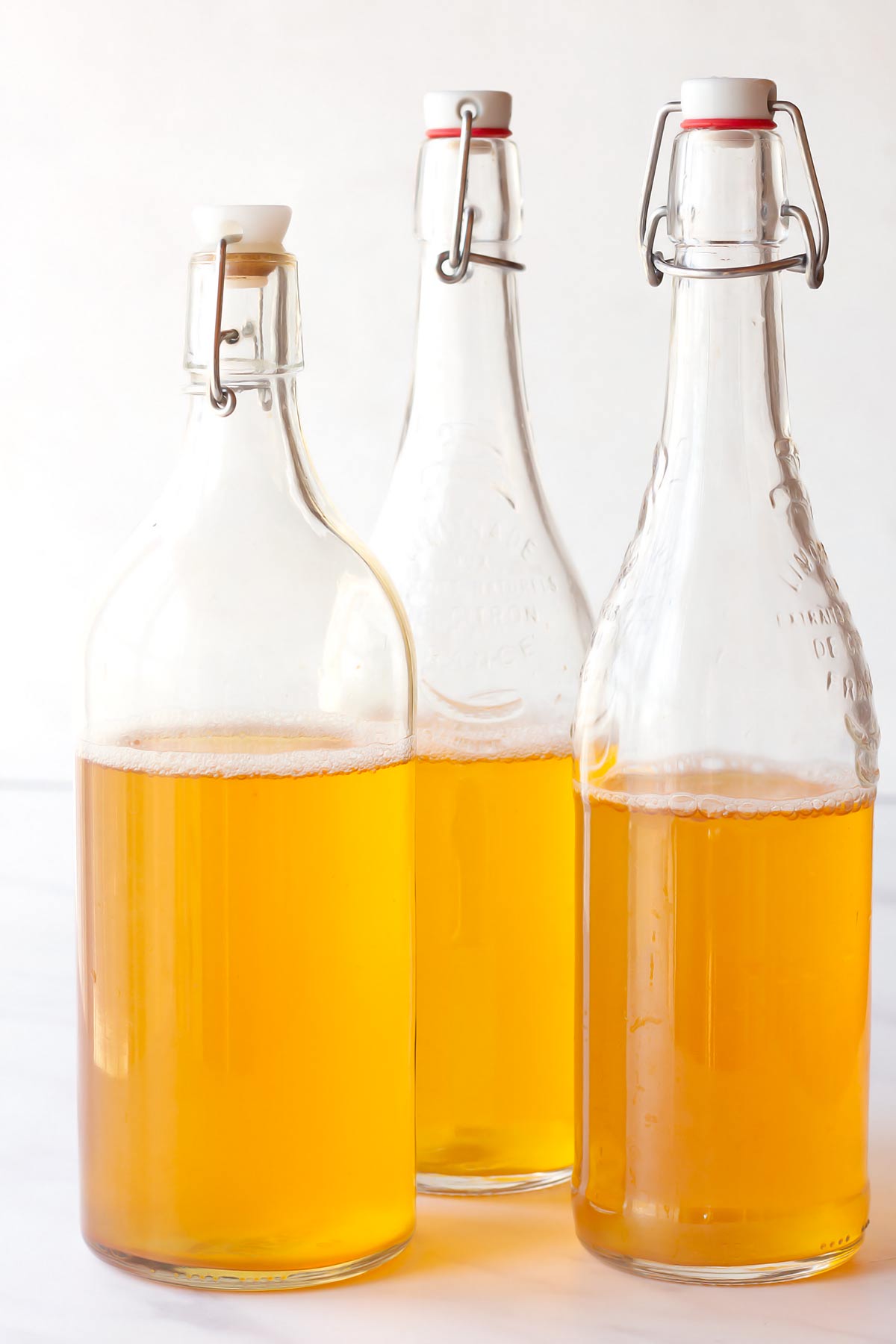 Brewed kombucha filled into 3 flip top glass bottles