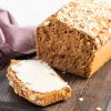 yeast free spelt bread loaf and one buttered slice