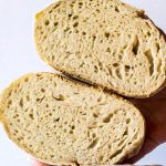 hand holding easy sourdough bread cut in half