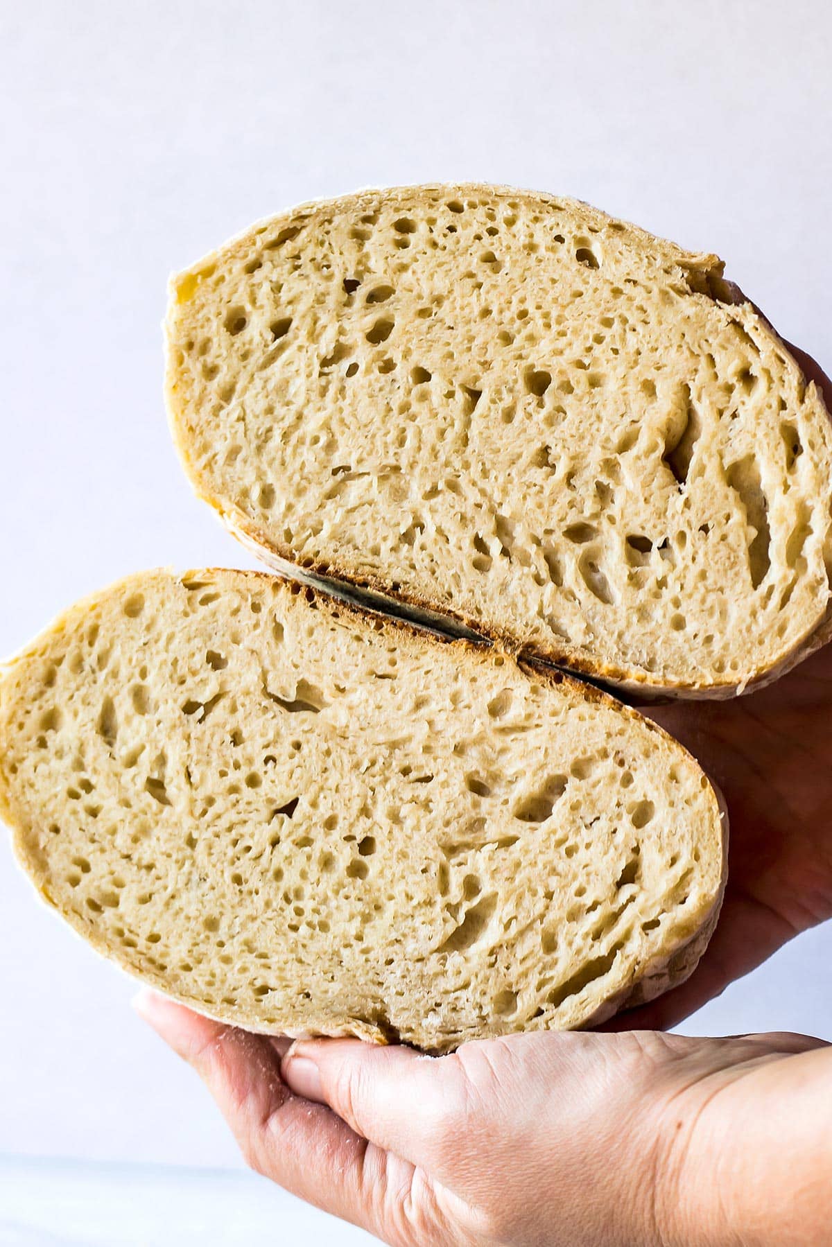 hand holding easy sourdough bread cut in half
