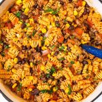 One Pot Taco Pasta on red Dutch oven with blue ladle