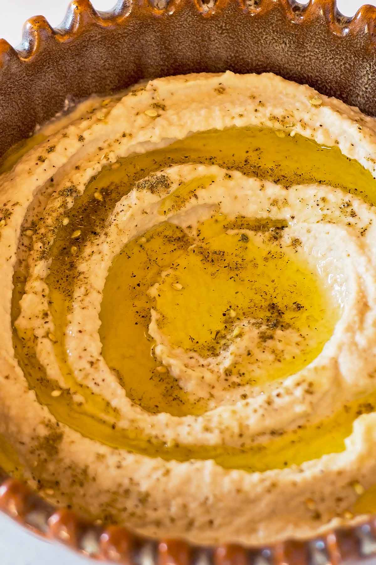 Best hummus spread in brown pottery bowl