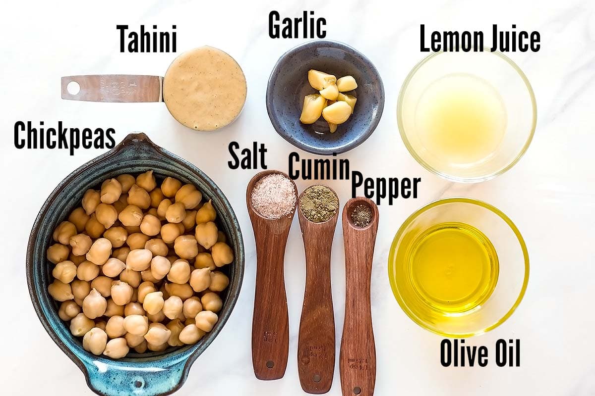 Ingredients for hummus in individual bowls and spoons