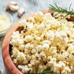 Garlic Parmesan Popcorn with rosemary in wooden snack bowl