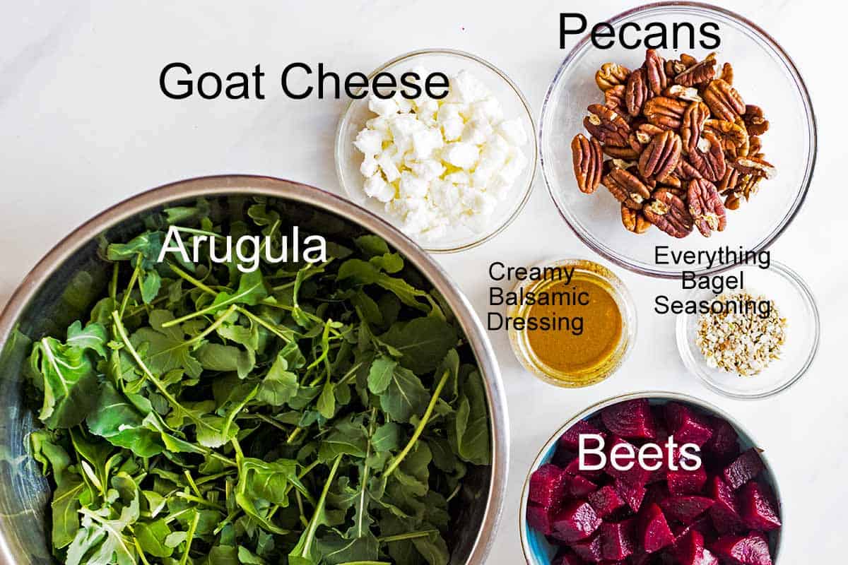 flat lay of arugula beet salad ingredients in indivudual bowls