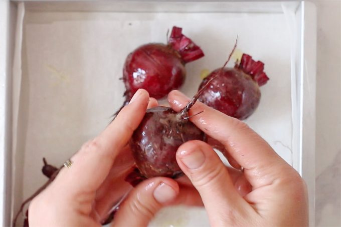 hands holding beet to coat with oil