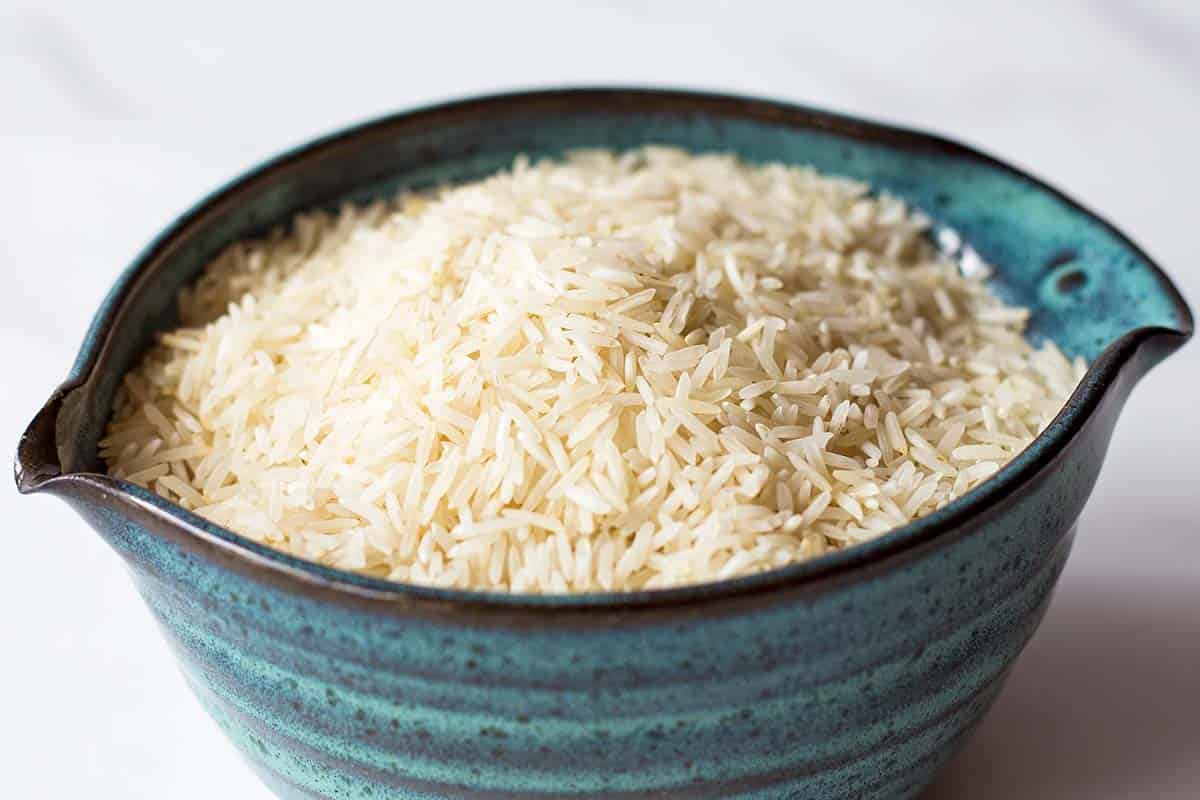 dry Basmati rice in blue ceramic bowl