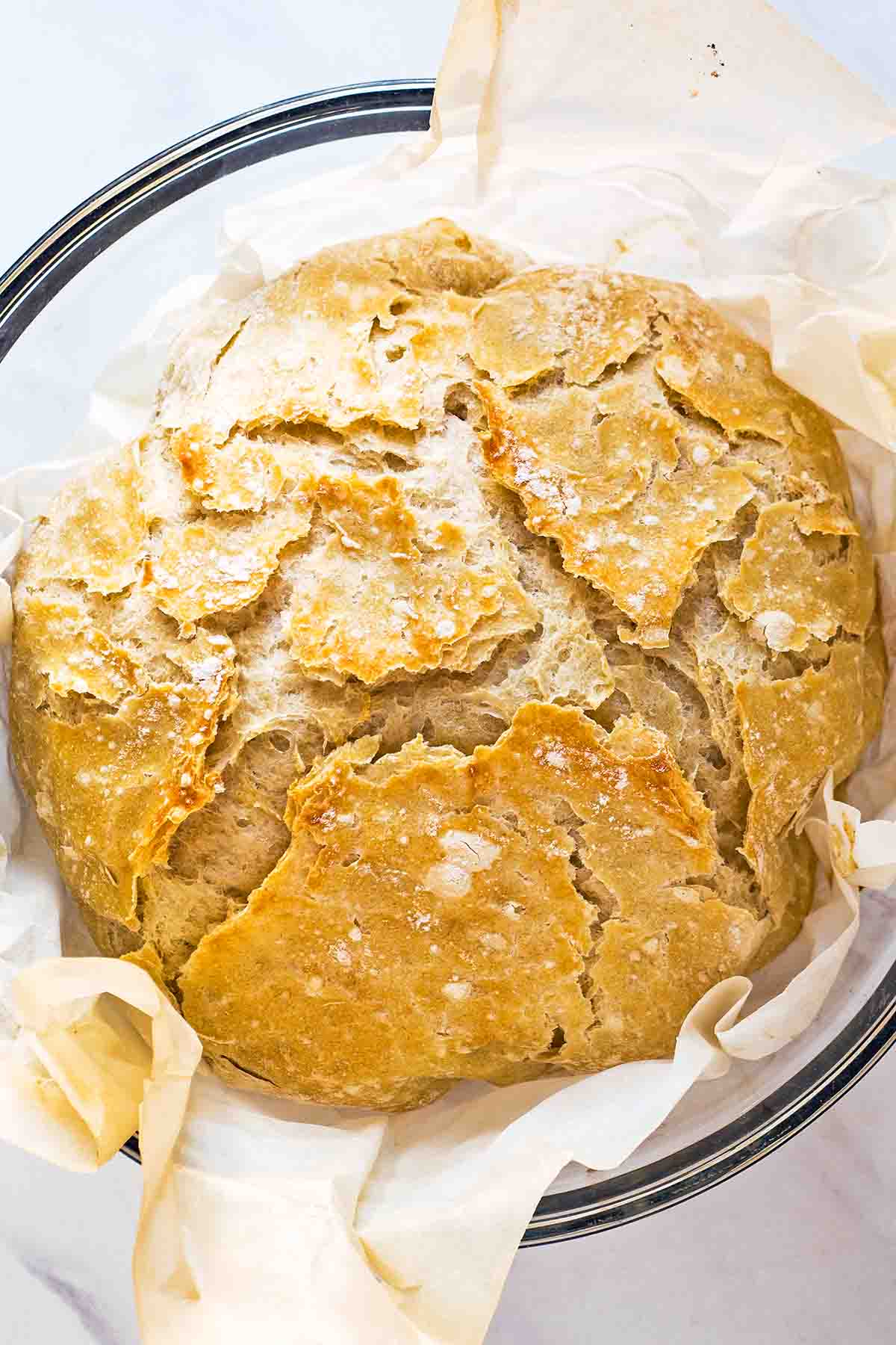 Overnight no knead bread in parchment lined glass bowl